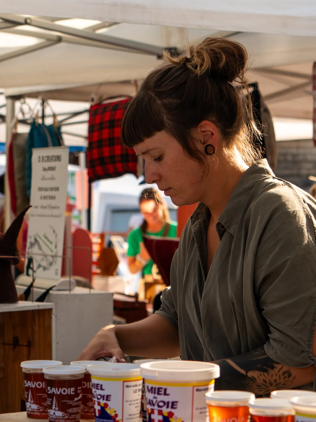 Juliette Bibollet sur son stand de marché, devant ses pots de miel de Savoie.